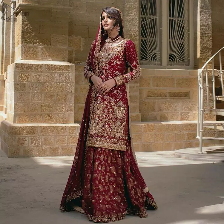 Designed with a round neckline, the shirt is full-sleeved which enhances its traditional magnificence. This graceful traditional bridal wear will definitely add to your perfection on the reception day.