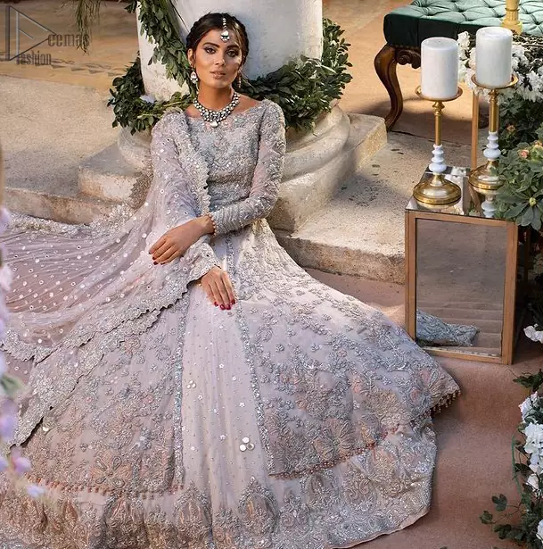 Beautiful Pakistani wedding dress in light peach front open pishwas with back train lehenga and emrboidered dupatta. This outfit brings drama and playfulness to traditional front open pishwas and lehenga with a modern approach. The mix of colours embroidery much of a choice for the festive season. The neckline is artistically decorated with kora, dabka, tilla, sequins and thread work. The rest of the outfit is adorned with floral bootis and finished with a scalloped hemline. Complete the look with an artfully coordinated lehenga which is ornamented with a bold and captivating back trail design with a traditional intricate embroidered. The classically balanced borders on the pure organza dupatta add exquisiteness to the look.
