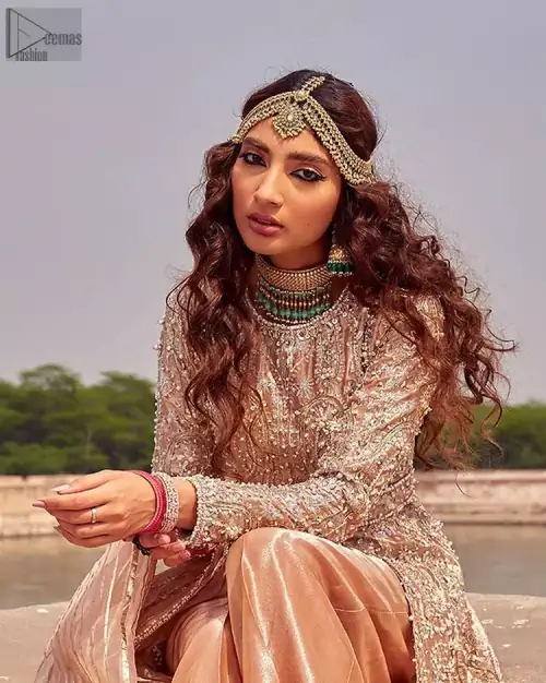 the dress with a tissue dupatta and graceful palazzo pants makes you the center of attention on your big day. Peach