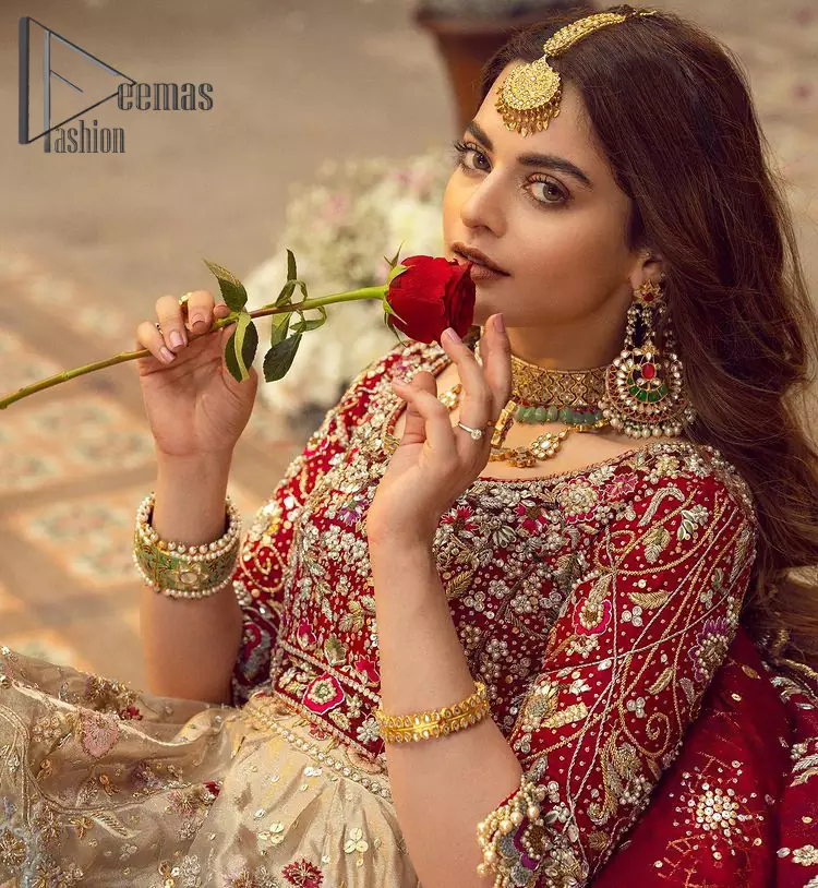 It's distinctive how the new-gen brides are welcoming red and beige shades for their bridal outfits as well. So Welcome your guest to this charming beige lehenga. The three quarter-sleeved Red Blouse got it all for you. In addition to this, the Beige lehenga has embellished border embroidery and floral embroidery in dabka, kora work that gives the stunning look. Furthermore, it is enhanced with embroidered applique bottom. The organza red dupatta that has a scalloped applique border all around the edges makes the look complete and comprehensive.