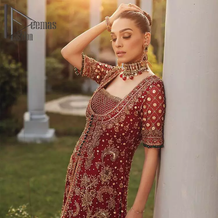Just fulfill your love for maroon on your Big day with DeemasFashion. Giving you all the glam with this maroon scalloped front open frock which is beautifully sprinkled with golden tilla, dabka, kora, crystal, and Resham thread work. In addition to this, the square neckline and half sleeves with multicolor embroidery look so stunning and soothing on your Big day. It is attractively synchronized with cigarette pants to grant you a remarkable aesthetic focusing look.