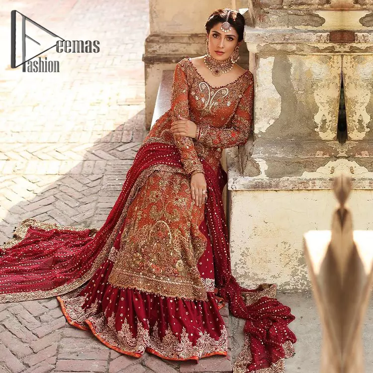 Wondering what an aesthetic bridal attire looks like? The beauty in red makes you go gaga over your look and you cannot stop snowing over you. Wearing the rust long shirt on your big day that is marvelously adorned with kora, dabka, and sequins work. Furthermore, the round neckline is also beautifully decorated to enhance the beauty of the outfit. It is synchronized with a red lehenga that has sequins sprayed all over to give you a crazy look as well. Finish this look with a red dupatta that has four-sided embellished lace as well.