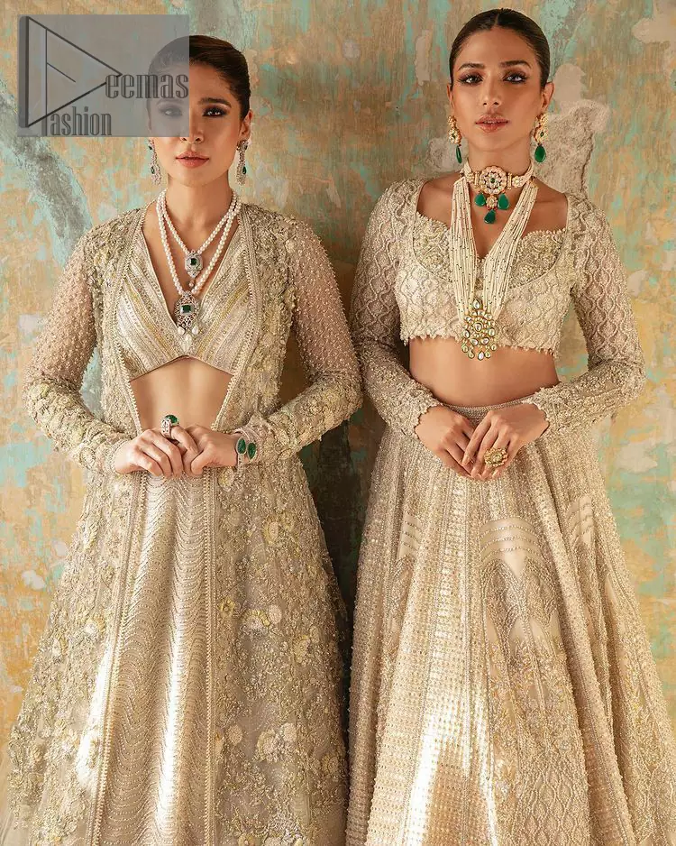 With a touch of Divine. A stunning ivory blouse is laboriously frosted with meticulously detailed hand embellishment with kora, dabka, tilla and pearls all over. The sweetheart neckline of the blouse and full sleeves together gives a so romantic look to any bride. In addition to this, it is systemized with the same colour frilled lehenga which is laden with the same colour embroidery that gives a magical stream of tilla, dabka and pearls. Finish this ivory article with the same colour dupatta that is heavily embellished with four-sided handsome borders and sequins sprayed all over to enhance the feeling of joy. 