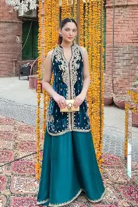 No matter the time and occasion, a pop of blue will always bring you in the bright light. This teal blue short shirt is an exquisite amalgamation of classical golden embroidery and modern cuts. It is prominent with tilla, dabka and kora so everyone looking at you in any event. The V shape neckline increases the beauty of the outfit when combined with the sleeveless style of DeemasFashion. Further, it is coordinated with the same colour palazzo pants that are the bottom line is embellished with golden tiny embroidery to enhance the brightness of your dress.