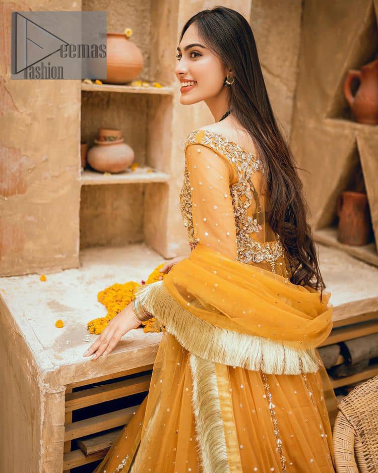 Mustard is just associated and boosts your Mehandi.  Presenting a dreamy mustard frock with a heavily embroidered bodice on a silver base. The bodice is further enhanced with handwork that includes crystal, tilla, kora and dabka work. Furthermore, the boat shape neckline and tiny work on full sleeves have the super style just to boost your day. The bottom is decorated with artistic embroidery that is adding glam to it. The Mehandi look is completed with an artistically crafted frilled lehenga which frill borders displaying the traditional hint of charm. It is coordinated with a dupatta in the same colour that is embellished with four-sided borders as well. 