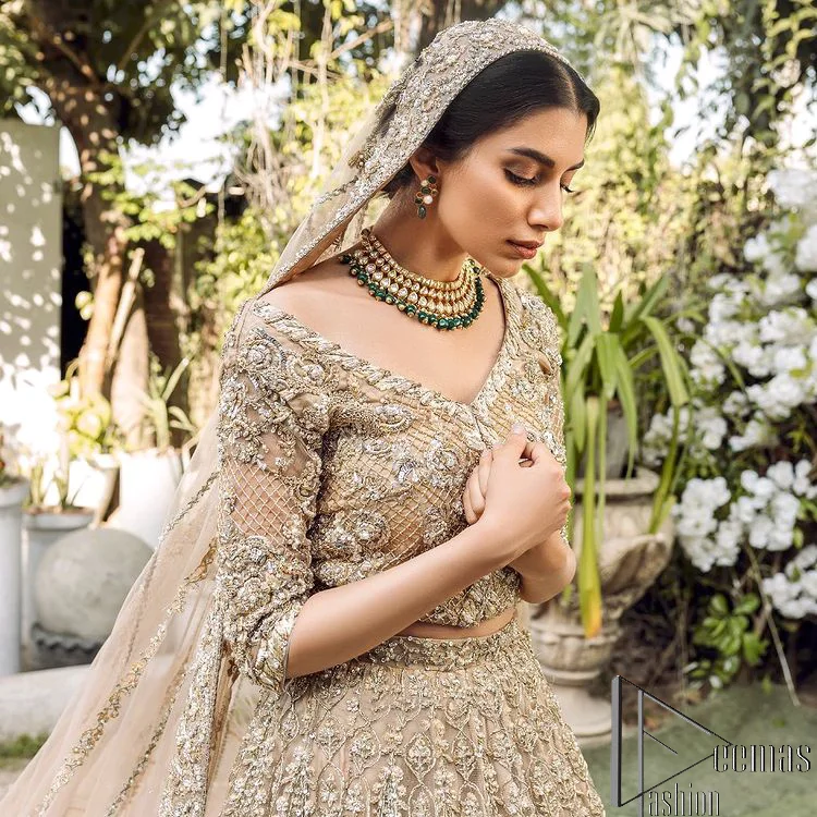 If you are getting married, you need a quality outfit. So, DeemasFashion presents this nikah outfit for you in fawn colour which begins with a fawn blouse that is laboriously and meticulously hand–rendered with silver and matching embroidery. It enhances with tilla, dabka, kora and Kundan that is portraying the dreamy vibe. The V Shape neckline of the blouse is a stylish way to steal the spotlight. The Nikah outfit is paired up with a can-can lehenga which is again heavily embellished with lushly detailed embroidery. Complete this nikah outfit with a dupatta in the same colour which is beautifully ornamented with a four-sided border which is ideal for modern festives.