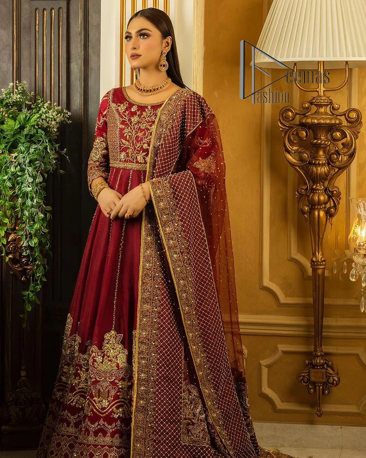 Maroon is the colour language to show bold and cuteness at the same time. DeemasFashion presents this Pakistani reception wear in the beautiful shade of maroon. Starting this Pakistani reception wear full-length Anarkali which is meticulously hand-rendered with golden embroidery which enhances the tilla, dabka, kora and Kundan to make your day with full confidence. Furthermore, it is highlighted with three-quarter sleeves and boat shape neckline. The Anarkali of this Pakistani reception wear is organized with a dupatta in the same colour which is embellished with four-sided borders and sequins sprayed all over.