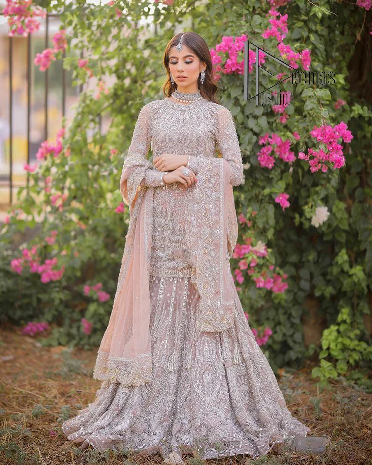Introducing the mauve nikah outfit which begins with a short shirt that is meticulously and laboriously hand-rendered with silver embroidery which is embellished with tilla, dabka, and Sitara. Furthermore, the full sleeves of this nikah outfit are more attractive when come with a round-shaped neckline. It is coordinated with a fish-style heavy lehenga which is again ornamented with silver embroidery. Complete this nikah wear with a scalloped dupatta which is embellished with four-sided borders and sequins sprayed all over.