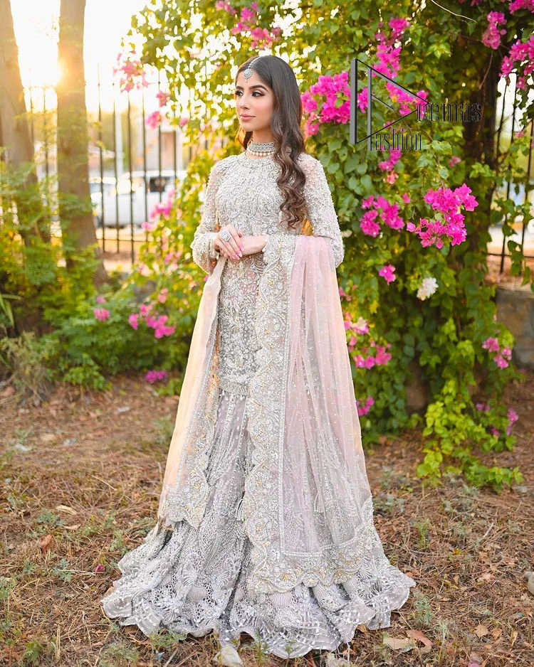Introducing the mauve nikah outfit which begins with a short shirt that is meticulously and laboriously hand-rendered with silver embroidery which is embellished with tilla, dabka, and Sitara. Furthermore, the full sleeves of this nikah outfit are more attractive when come with a round-shaped neckline. It is coordinated with a fish-style heavy lehenga which is again ornamented with silver embroidery. Complete this nikah wear with a scalloped dupatta which is embellished with four-sided borders and sequins sprayed all over.
