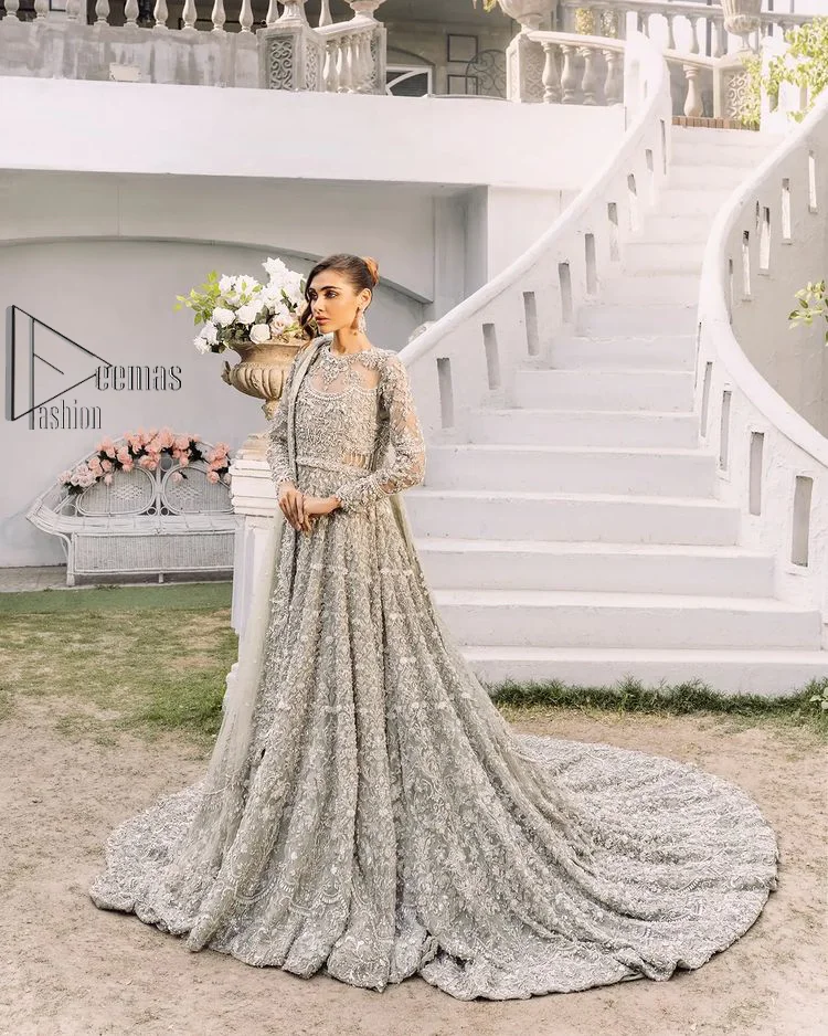 It was love at first swipe! Presenting this olive green back train maxi which is laboriously hand-rendered with silver and matching embroidery to make you a pure soulful bride. It is enhanced with tilla, dabka, kora and Kundan. The illusion neckline adds more beauty to this walima wear when comes with full sleeves. The back train flare is made just for you to catch more and more love from your loved ones. Complete this walima wear with a dupatta in the same colour which is handsomely embellished with a four-sided heavy border and sequins sprayed all over to receive more love.