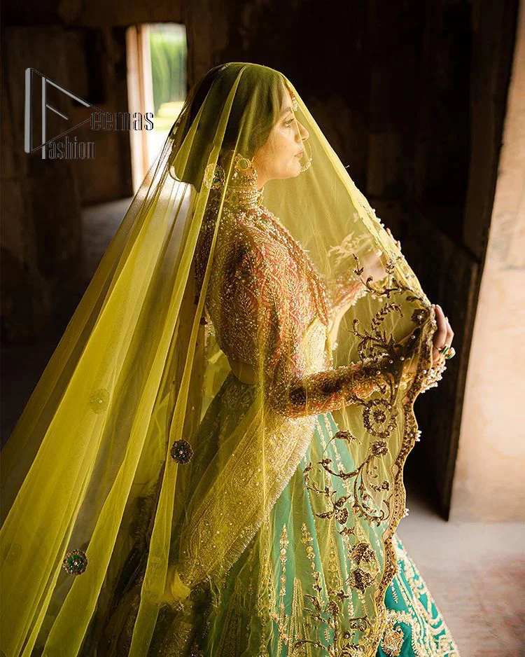 The blushing moment you found your dream mehndi outfit. This mehndi outfit is handsomely and attractively prepared in the level of contrast. Starting this mehndi outfit with a red blouse which is laboriously hand-rendered with light golden embroidery having tilla, kora, dabka and zardozi. In addition to this, it is enhanced with full sleeves and boat shape neckline to make your day super blush. The mehndi outfit is coordinated with a bottle green lehenga which is heavily ornamented with golden embroidery. Complete this article with a golden dupatta having Kiran on all sides. 