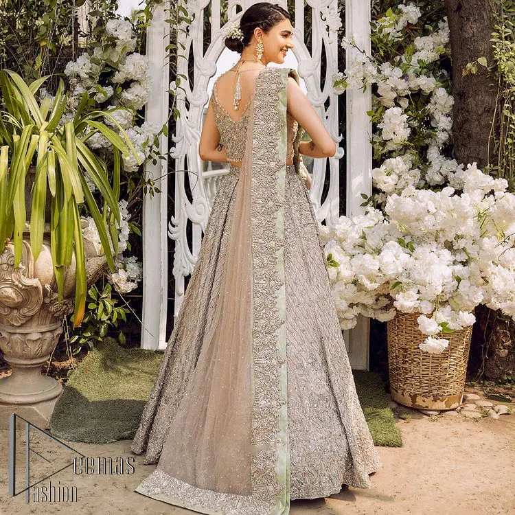 Go with tea rose on your Big day. DeemasFashion presents tea rose nikah wear to fulfil your dreamy look. The blouse in the tea rose colour is heavily ornamented with silver embroidery that enhances with tilla, dabka, kora and zardozi. Further, It is detailed with a round neckline and finished with a sleeveless style. The nikah wear is paired up with can-can lehenga which is heavily embellished to make you the spotlight among all. Complete this article with a dupatta which is enhanced with four-sided embellished borders and sequins sprayed all over to make your day more memorable and attractive.