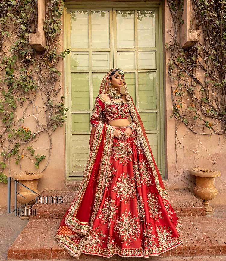 Nothing beats the luxury of bright red couture in reception. Our luxury bright red blouse is entirely hand-worked and finished with the fine material of golden embroidery which is self-explanatory of the uniqueness of the attire. It is further enhanced with tilla, dabka, kora and Sitara. The boat shape neckline also added engaging and attractive beauty to the outfit when comes to full sleeves. It is organized with flared lehenga to make your day super amazing and fulfil your dreamy romantic look. Complete this with a dupatta which is embellished with four-sided borders and sequins sprayed all over to beat the luxury of bright red.
