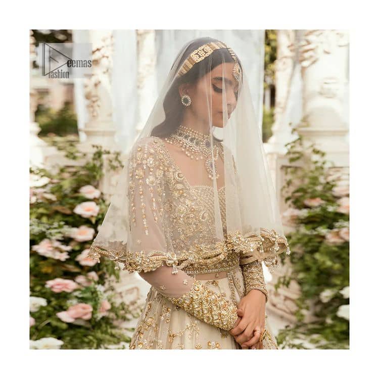 Mark your Nikah day in a calendar as a special one with this marvellous outfit. DeemasFashion presents this outfit in light fawn colour which begins with a back train scalloped maxi. The following maxi is sumptuously embellished with a golden embroidery which is further intensified with tilla, dabka, naqshi, Resham and zardozi. The sweetheart neckline of the maxi is heavily embellished and looks romantic when comes with full sleeves style. It is handsomely paired up with a lehenga in the same colour which is so plain to balance the look of the outfit. Finish this article with a scalloped dupatta which is embellished with four-sided borders and sequins sprayed all over to make your day more magical. 
