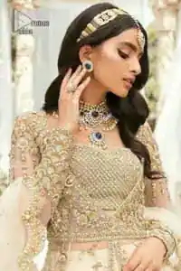 Mark your Nikah day in a calendar as a special one with this marvellous outfit. DeemasFashion presents this outfit in light fawn colour which begins with a back train scalloped maxi. The following maxi is sumptuously embellished with a golden embroidery which is further intensified with tilla, dabka, naqshi, Resham and zardozi. The sweetheart neckline of the maxi is heavily embellished and looks romantic when comes with full sleeves style. It is handsomely paired up with a lehenga in the same colour which is so plain to balance the look of the outfit. Finish this article with a scalloped dupatta which is embellished with four-sided borders and sequins sprayed all over to make your day more magical. 