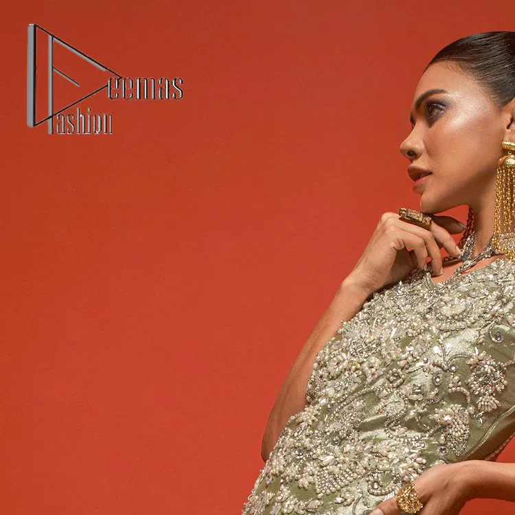 Celebrate your party events with DeemasFashion. An olive green shirt in tissue fabric, hand embellished with dabka, nakshi, cut dana, Resham, Swarovski, Mukesh, sequin and Kundan. A heavily embellished bodice featuring floral patterns all over to make your party event marvellous and shiny. The following heavy shirt is enhanced with V shape neckline along the sleeveless style. The bottom of the shirt has handsome fringes to give you a charming and splendid look.