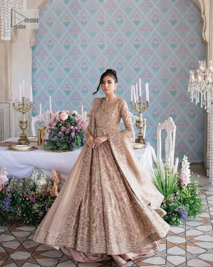 Make your Qabool Hai moment more memorable with this outfit by DeemasFashion. A dreamy statement of this dress proffers a soft pink hue with glamorous silver and golden embroidery.  It is further enhanced with tilla, dabka, kora, Kundan and the real magic of zardozi. V neckline enhances the overall glamour of this masterpiece. Intricate designs and fine details on the sleeves give a perfect finishing look to this maxi. The maxi is layered over a meticulously handcrafted lehnga which is bold enough to stand out in the crowd. Finish this article with a dupatta which is ornamented with four-sided borders and sequins sprayed all over which is a unique piece for your Nikah look. 