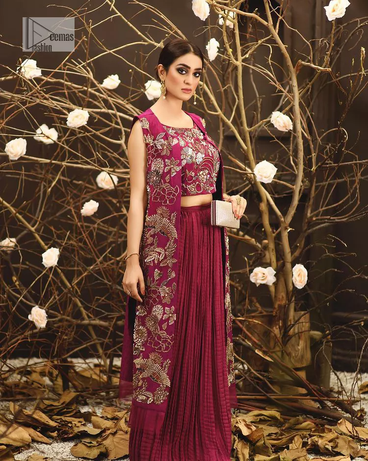 Sumptuously burgundy! This alluring outfit is surely any girl’s dream. DeemasFashion presents the three-piece outfit to make your event super bright. The blouse is handsomely laden with multiple colour embroidery. Beaming ornaments, zardozi, tilla,dabka, kora and Kundan make this blouse an epitome of grace. The boat shape neckline of the blouse a glamorous touch to this beautiful masterpiece. Paired up with a front open gown, hand-crafted beaming embellishments and luxury designs give a unique artistic look. The sleeveless style of the gown gives a royal appearance. Complete this article with a crushed skirt making it a perfect choice to pair with the blouse and gown.
