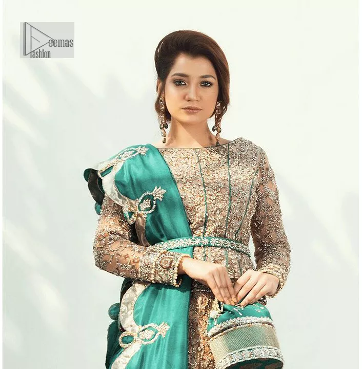 Celebrate your party with a bang and steal everyone's heart. The beautiful blouse in teal green shade comes in organza fabric. The boat shape neckline and full sleeves of this organza blouse are emblazoned with luxury details and intricate designs. Graceful golden embroidery that enhances with tilla, dabka, kora, Kundan, Zardozi and crystals to give a perfect finishing look to the blouse. It is organized with a back train lehenga which is heavily adorned with embroidery to make this masterpiece super aesthetic. Finish this outfit with a scalloped dupatta having four-sided embellished borders for a fine finishing look.