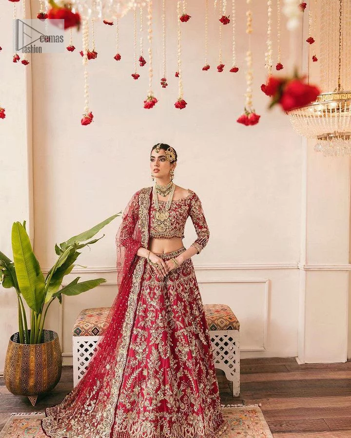 The beauty of this ensemble is mirrored in the romantic colour palette! The blouse is in a dark red shade and is fully decorated with intricate designs and fine details of goldwork. Lavish embroidery, tilla,dabka, kora, Kundan, gold, and zari work make this reception outfit a charismatic masterpiece. The boat shape neckline on a scalloped blouse gives the gorgeous Bride a head-turning look. In addition to this, the three-quarter sleeves for a more upscale appearance and feel. It is systemized with a lehenga in the same colour adorned with heavy floral patterns that are essential for your dreamy look. Complete this romantic look with a dupatta framed with four-sided embellished borders and sequins sprayed all over. Still, thinking? This is a no-brainer. Get your hands on this one ASAP before it sells out!