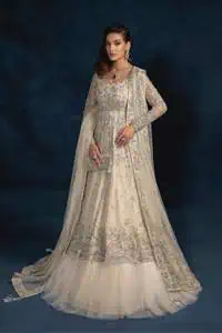 A sophisticated splash of off-white as your nikah outfit! With its round neckline and full sleeves, this outfit has a fine fusion look. Utilizing attractive silver embellishment work to enhance its intricate beauty. Tilla, dabka, kora, Kundan and the details of Zardozi beautifully embellish the elegant frock. It is paired with a flared lehenga to balance the overall look of this charming article. Finish this soft and bold look with a heavily bordered four-sided dupatta with a spray of sequins all over to make your Big day super aesthetic.