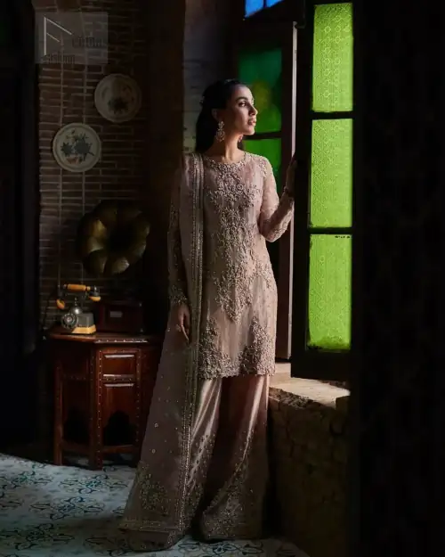 This elegant ensemble is thoughtfully designed with dark antique shades of embroidery which involves tilla, dabka, Kora, Kundan, and minimalist