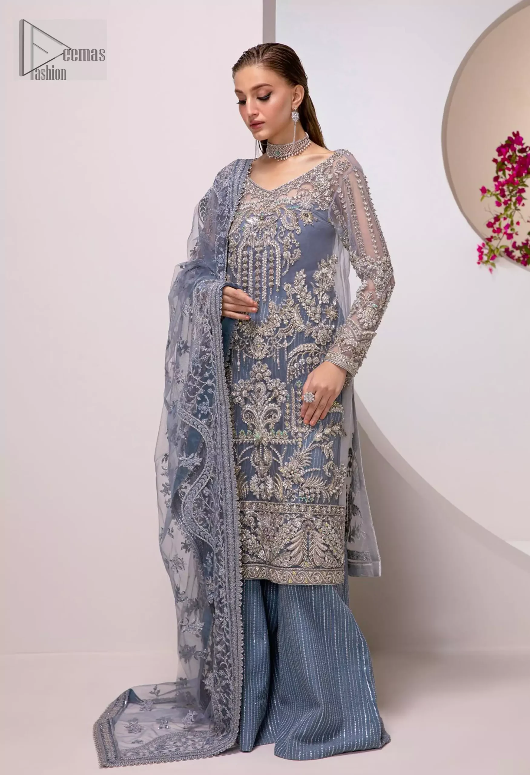 The flowing organza dupatta drapes beautifully, while the sharara adds a touch of regal charm, perfect for the modern bride. Float through your special day in this enchanting attire that embodies grace and understated glamour.