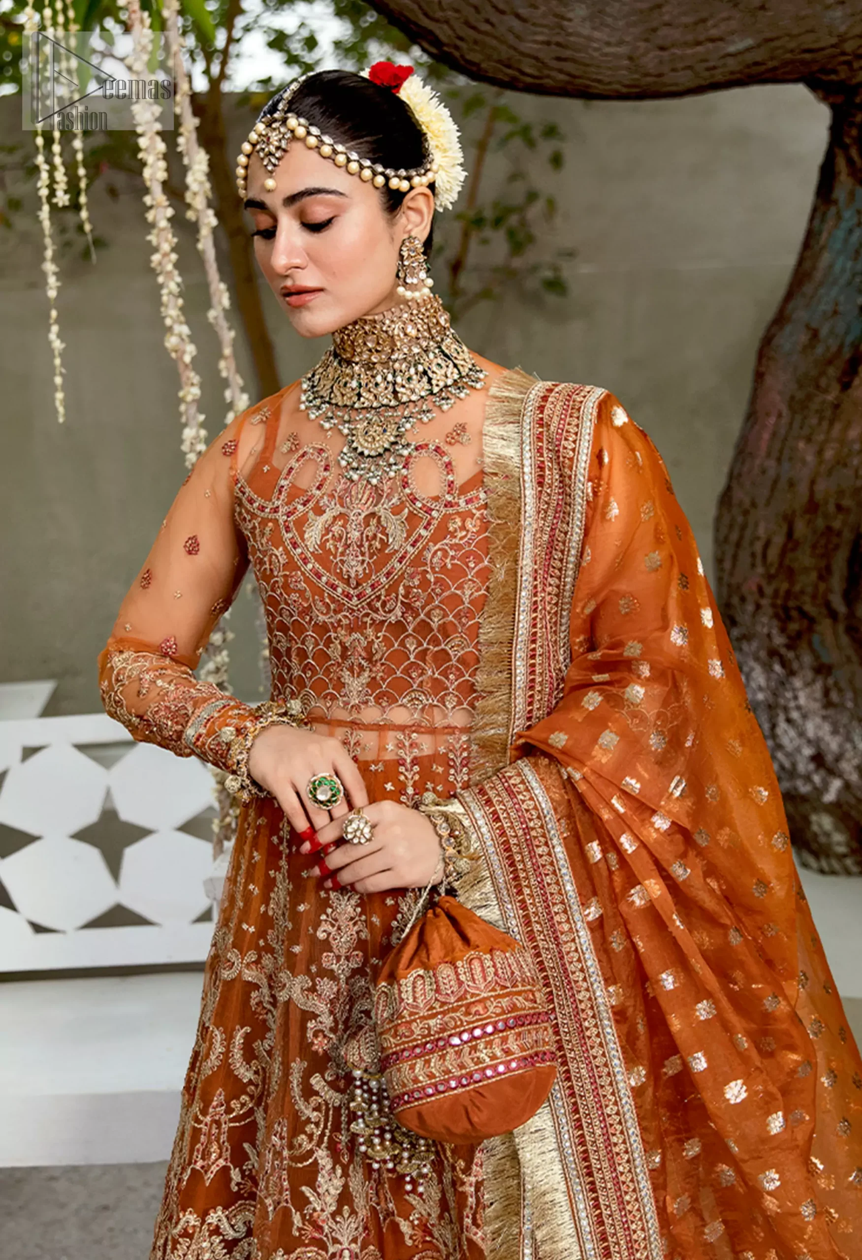 This outfit enchants with its warm rust tones, perfect for the vibrant mehndi night. The embellished bodice with delicate golden embroidery glimmers softly, while danglings and appliqué details add a touch of whimsy.