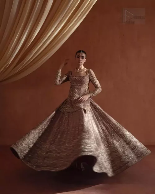 Hemline Craftsmanship: The finished edges and embellished hemline of the flared golden lehenga, embodying bridal sophistication.